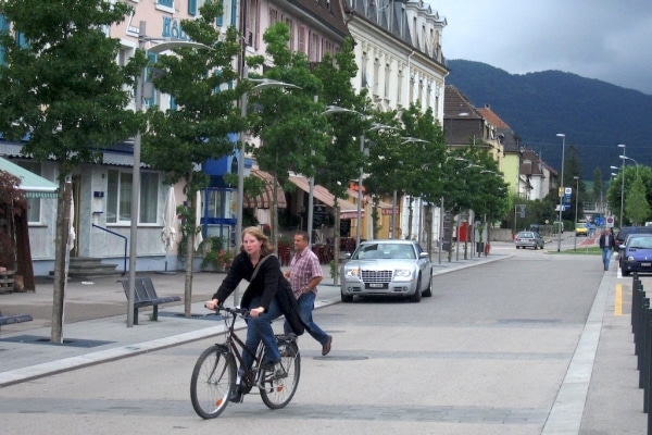 Piétons, cyclistes, bus et voitures se partagent l'espace. Source: Rue de l'Avenir